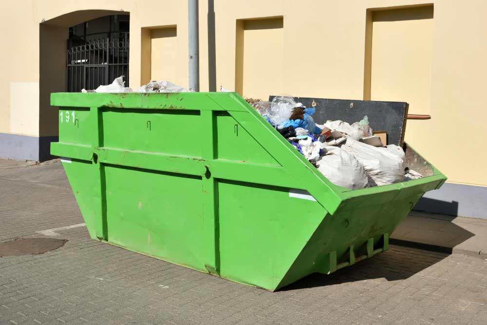 Green Skip On The Street Collecting Community Waste